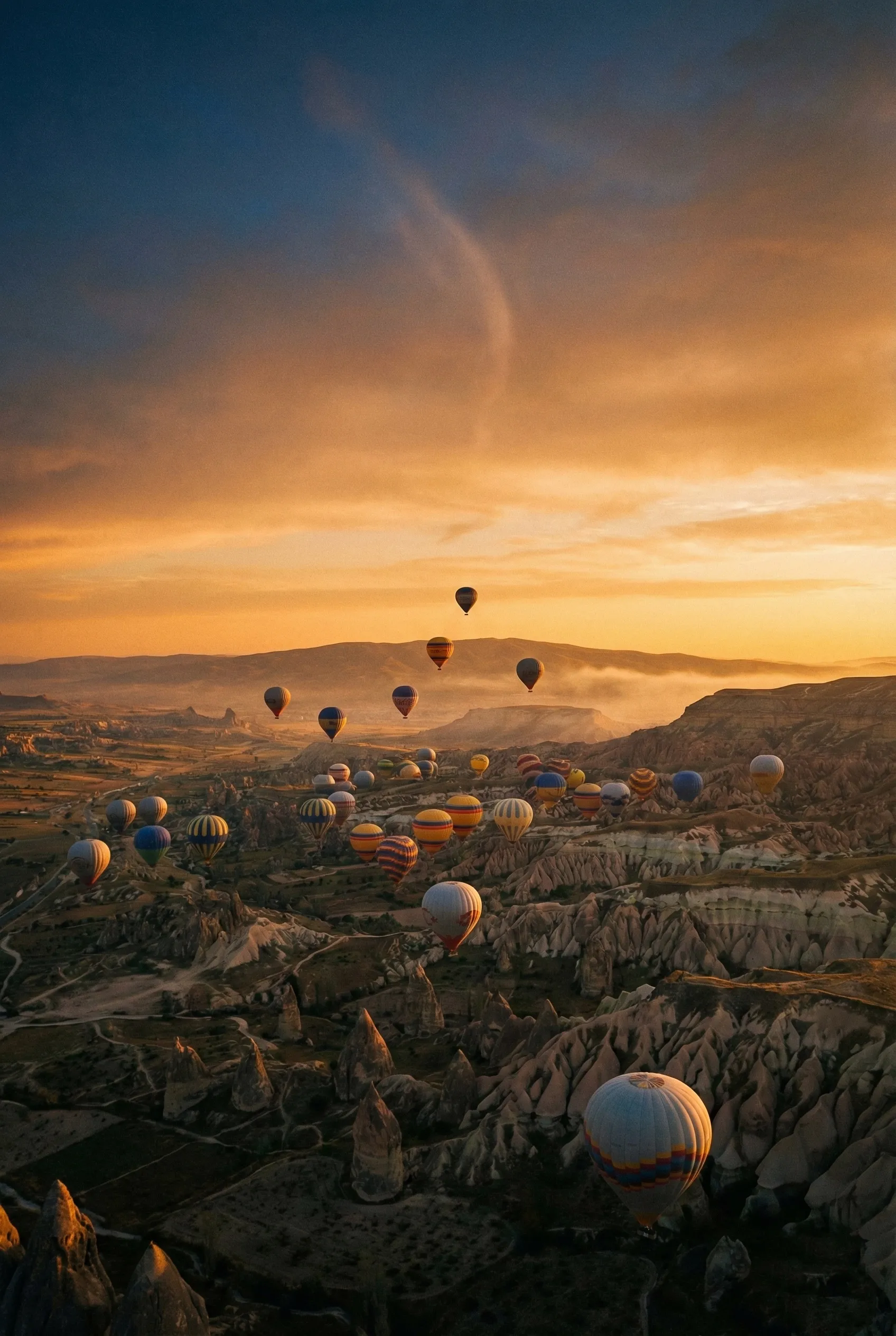 Kapadokya'da gün doğarken uçan sıcak hava balonları ve Panacea Balon Sigortası güvencesi. (insurance)