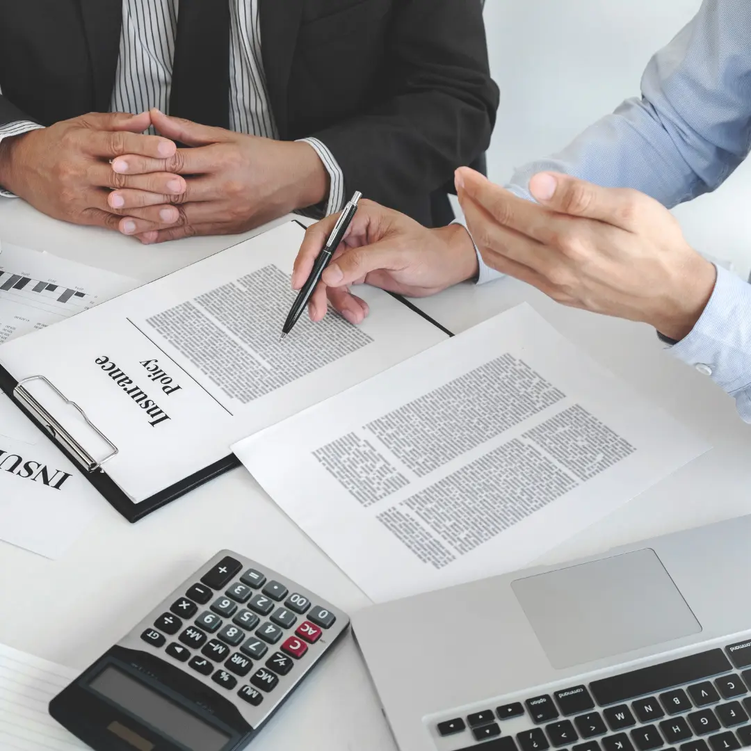 An insurance consultant explaining a policy document that shows an additional premium applied for higher risk assessment.