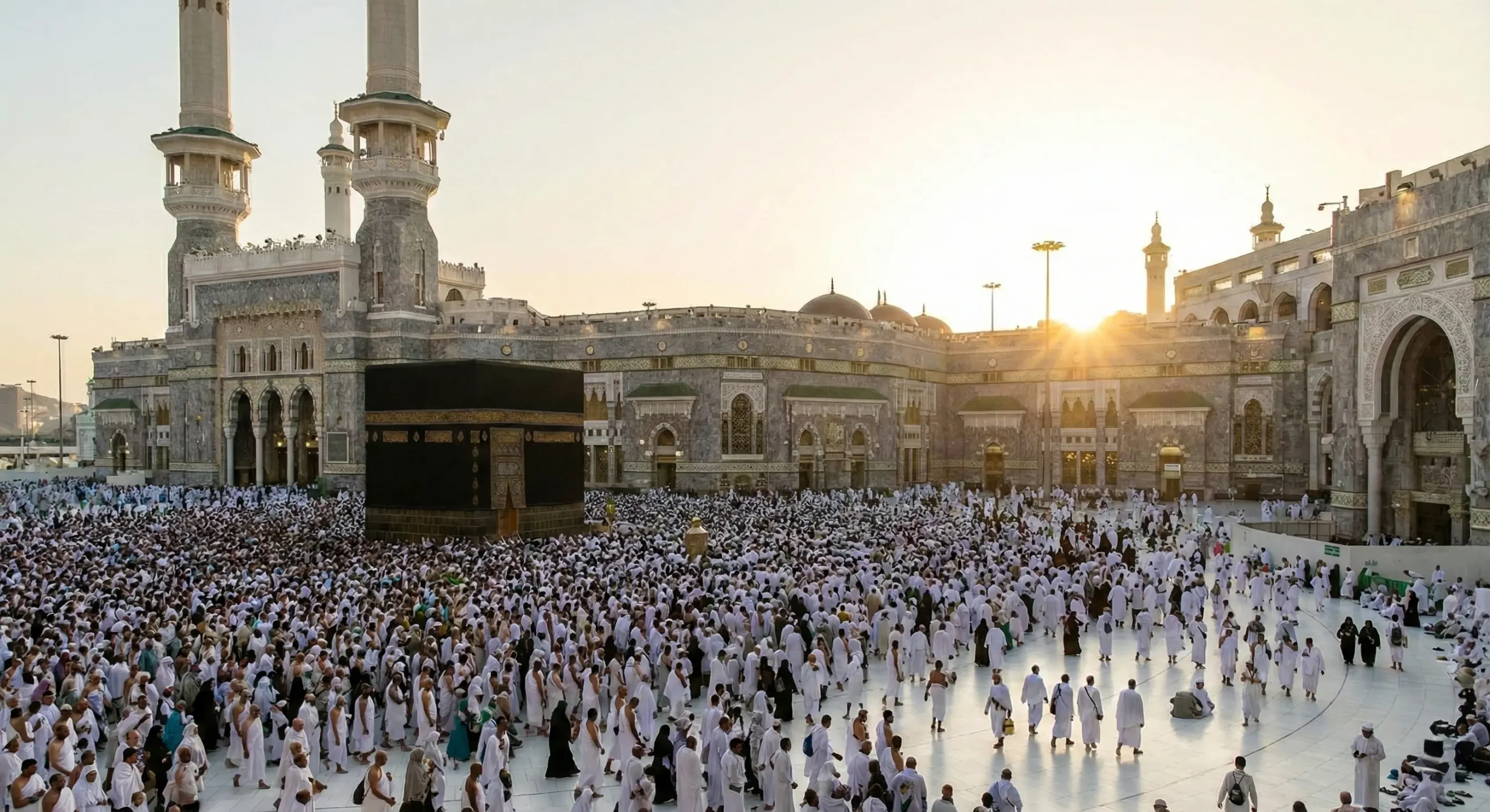 Suudi Arabistan'ın Mekke şehrindeki Mescid-i Haram avlusunda, binlerce Müslümanın Kabe'nin etrafında tavaf ettiği, güneşin doğuşu veya batışı sırasındaki panoramik fotoğraf.