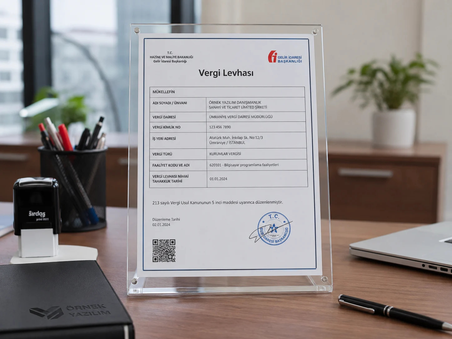 Masa üzerinde şeffaf çerçeve içinde sergilenen bir vergi levhası; görsel, “vergi levhası nedir” konusunu anlatan kurumsal bir ofis ortamını göstermektedir.